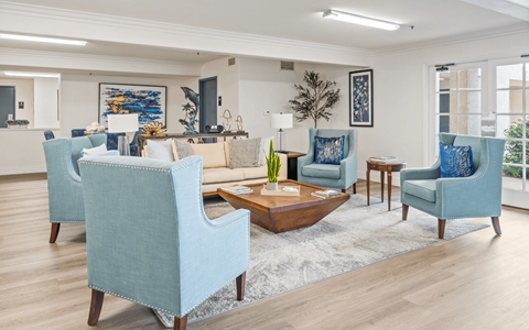 A living room with blue chairs and a wooden coffee table.