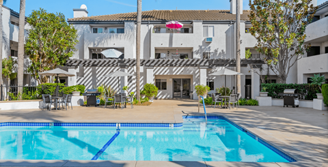a swimming pool in front of a white building with a pool