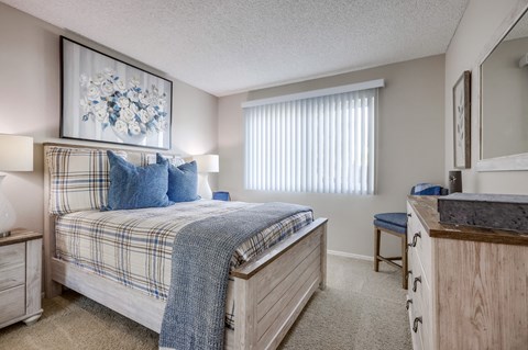 a bedroom with a bed and a dresser and a window