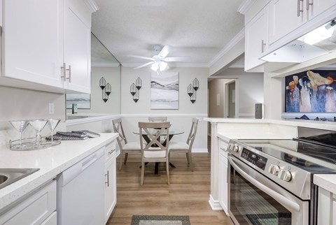 A kitchen with white cabinets and a black stove top oven.