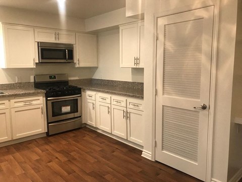 a kitchen with white cabinets and stainless steel appliances