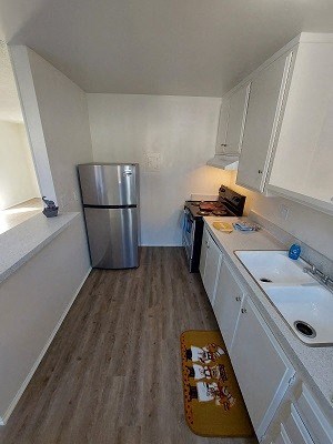 a small kitchen with a stainless steel refrigerator