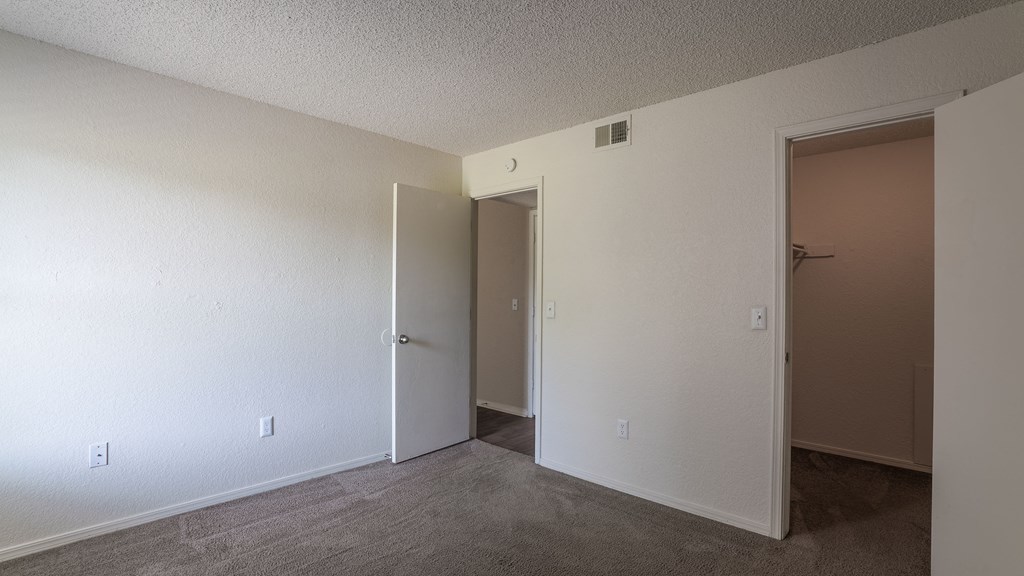 an empty living room with a door open to a closet