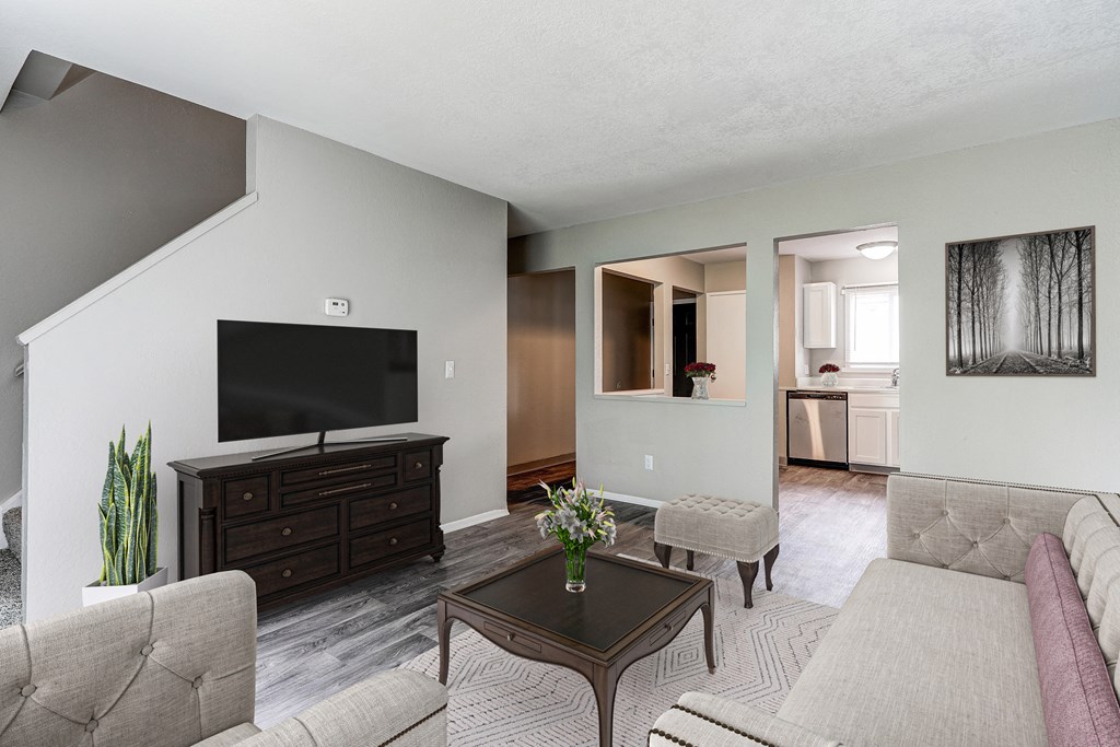A living room with a grey couch, a brown coffee table, and a flat screen TV.