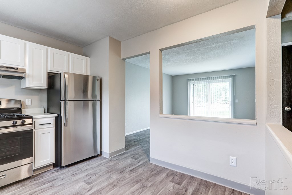 A kitchen with a stainless steel refrigerator and oven.