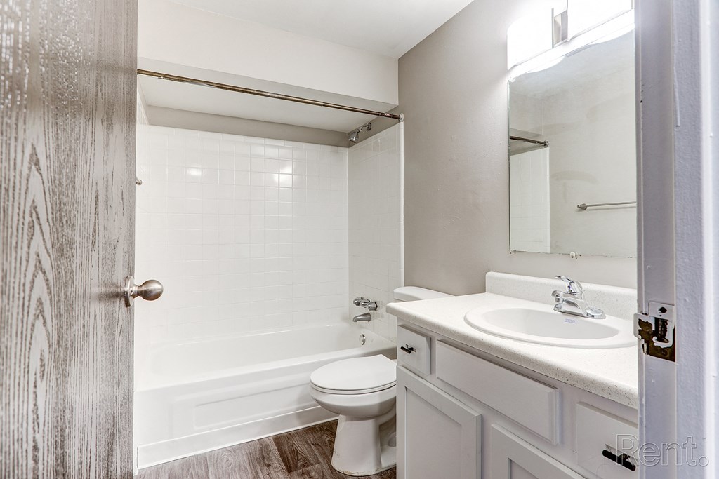 A white bathroom with a toilet, sink, and shower.