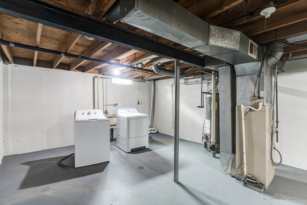 A room with a white tank and a white box on the floor.
