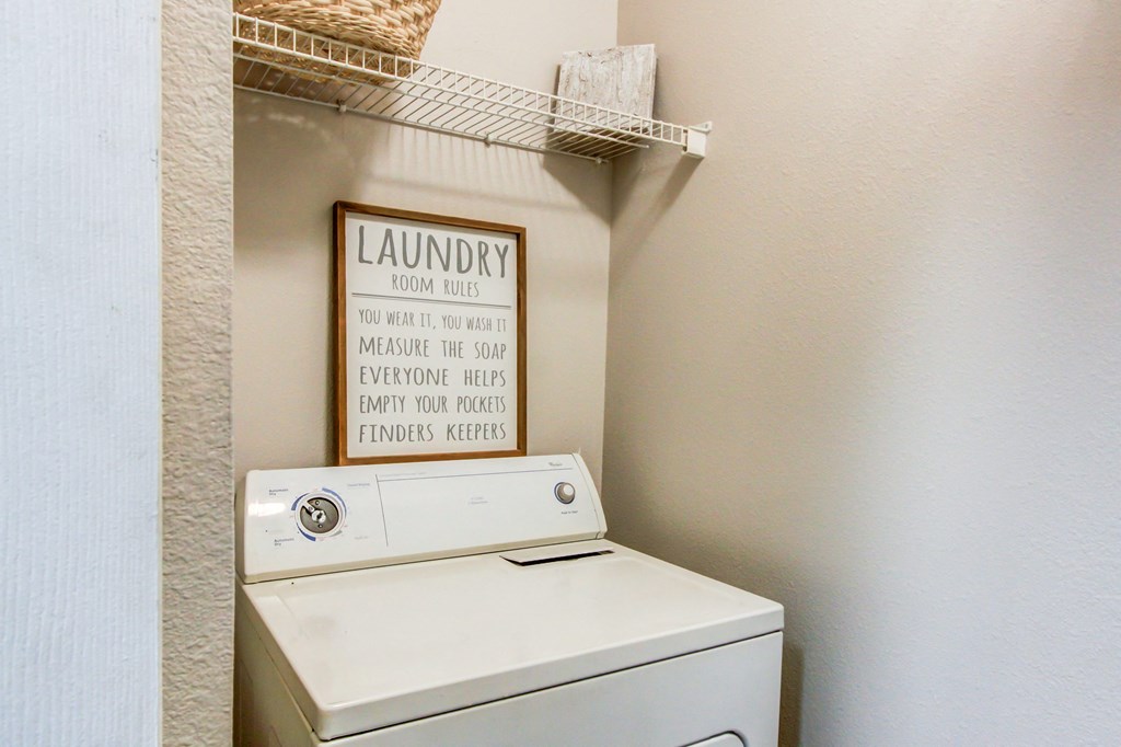 a washer and dryer in a laundry room with a sign on the wall