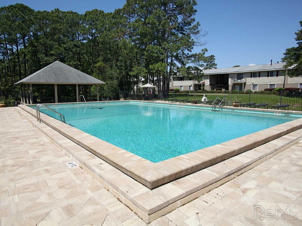 A rectangular pool with a pavilion in the background.