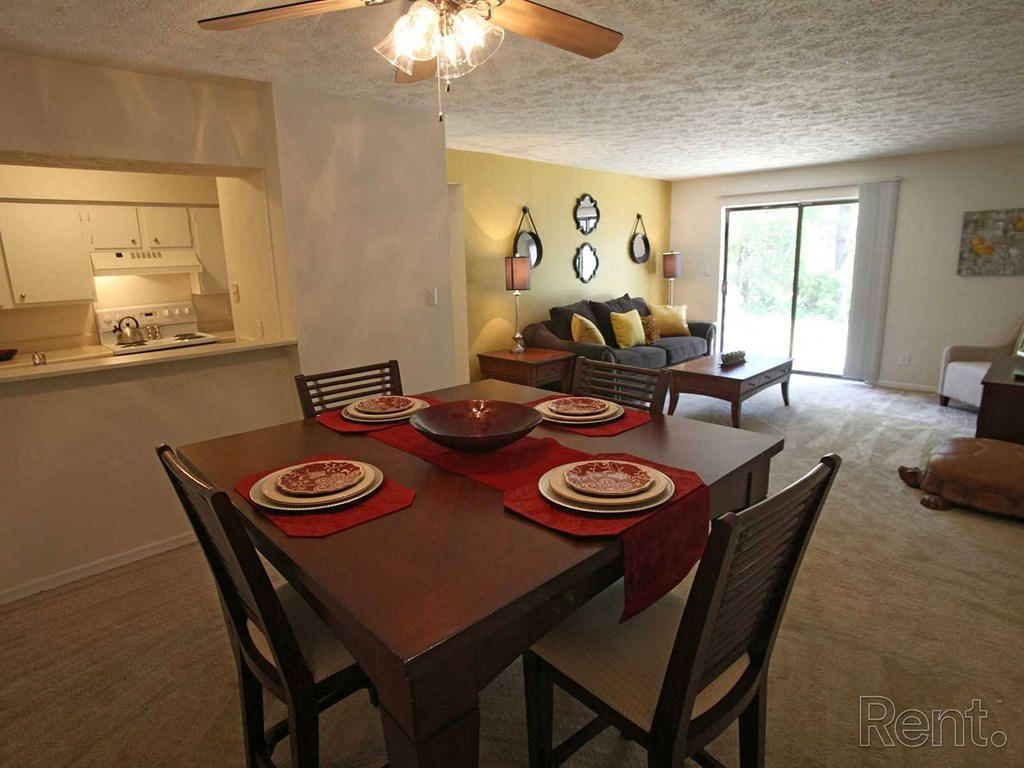 A dining room with a table set for a meal.