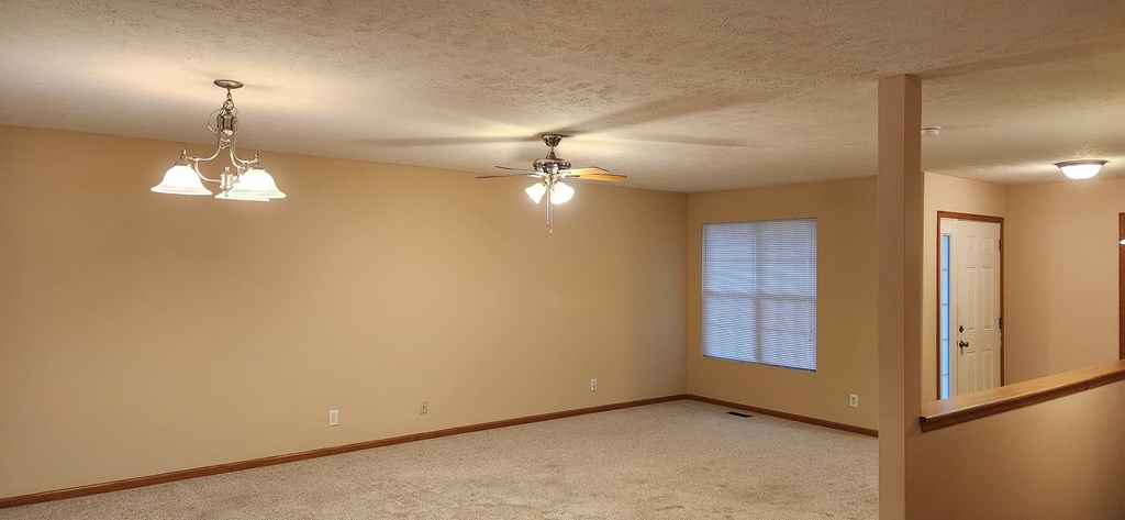 A room with a ceiling fan and a window.