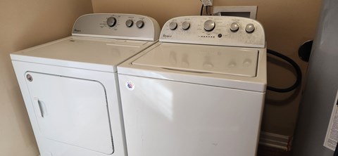 Two white washing machines in a small room.