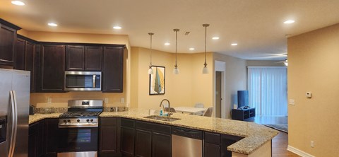 A kitchen with black cabinets and granite countertops.