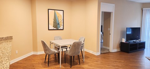 A dining room with a white table and chairs.