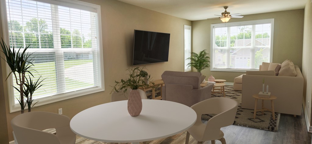 A living room with a white table and chairs, a flat screen TV, and a window with blinds.
