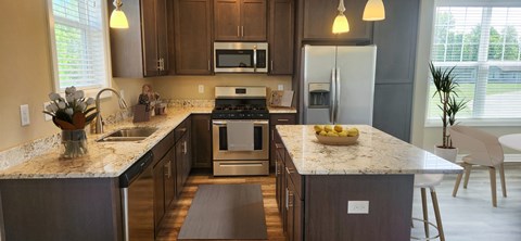A kitchen with a marble countertop and a refrigerator.
