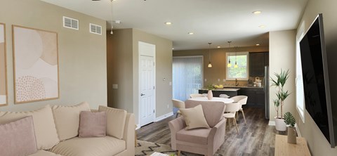 A living room with a couch, chairs, and a television.