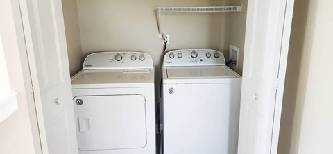 A white dryer and washer in a small laundry room.