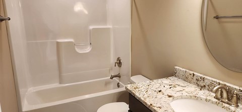 A white bathroom with a toilet, sink and tub.