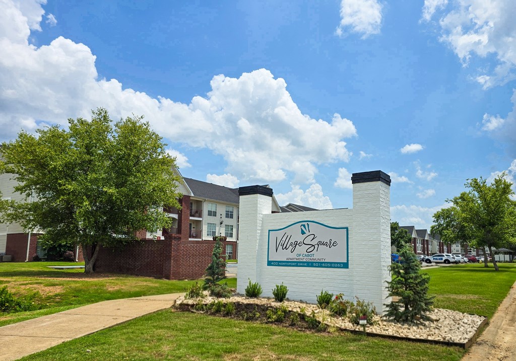 A sign for Village Springs stands in front of a building.