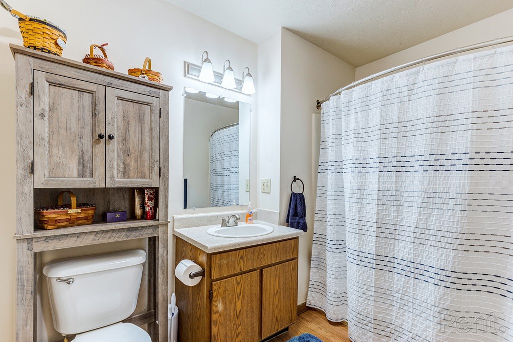 a bathroom with a shower and a sink and a toilet