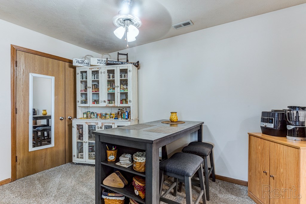 a breakfast bar with stools in the corner of a living room with a kitchen