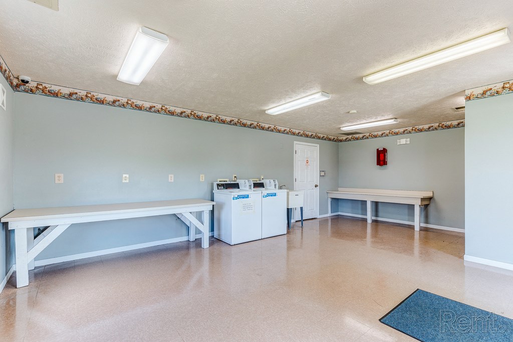 an empty room with two benches and two washing machines