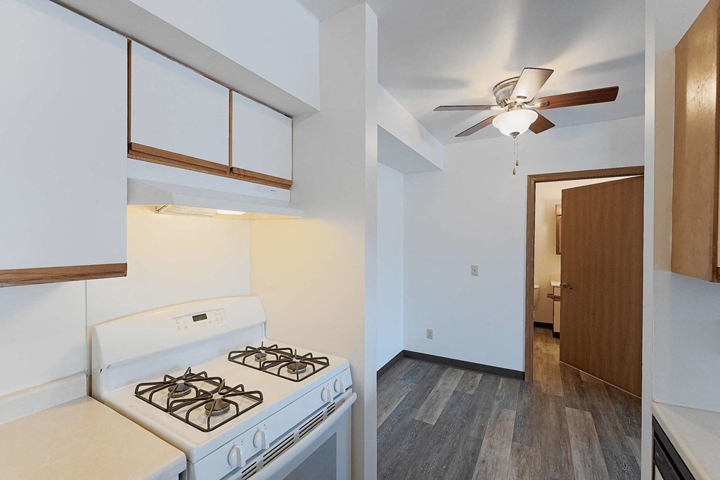 a kitchen with a white stove and a ceiling fan