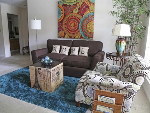 a living room with a brown couch and a rug