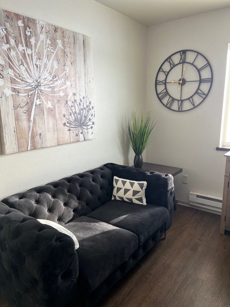 a living room with a couch and a clock on the wall