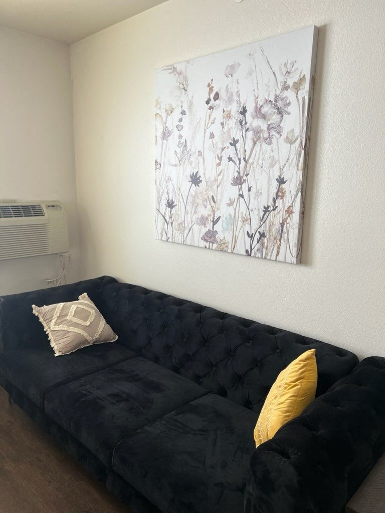 a living room with a couch and a painting on the wall