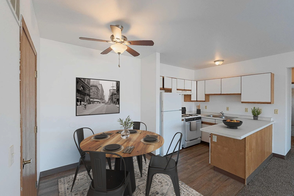 A kitchen with a table and chairs in front of it.