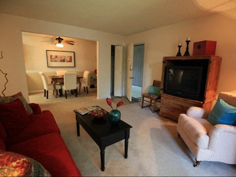 A living room with a red couch and a black coffee table.