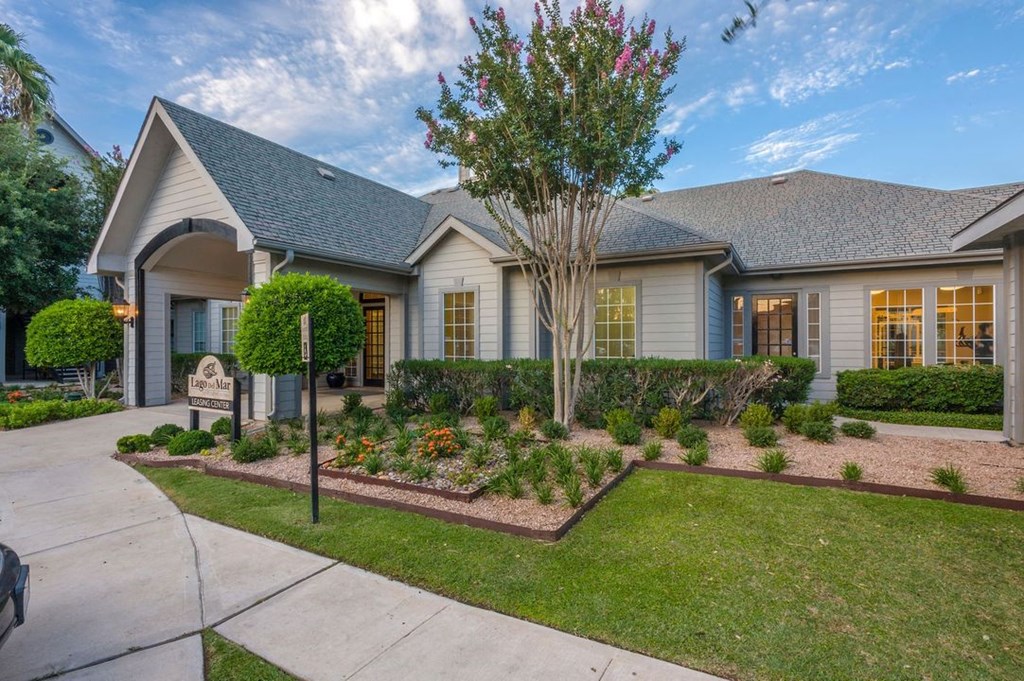 a house with a garden and a sidewalk in front of it