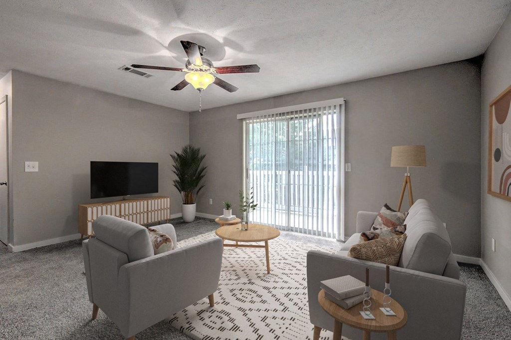 a living room with couches and a ceiling fan