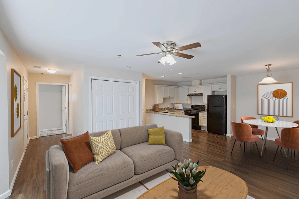 A living room with a grey couch and a brown pillow.