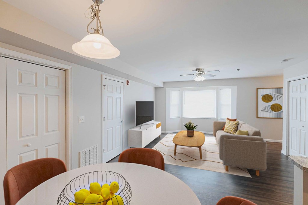 A living room with a white table and a bowl of lemons on it.