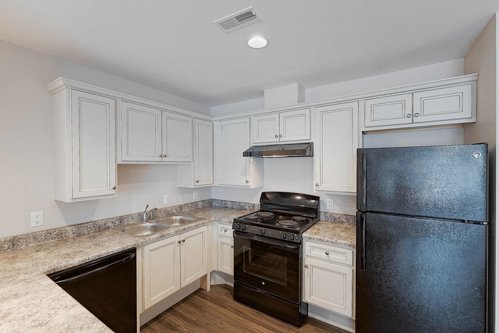 a kitchen with white cabinets and black appliances
