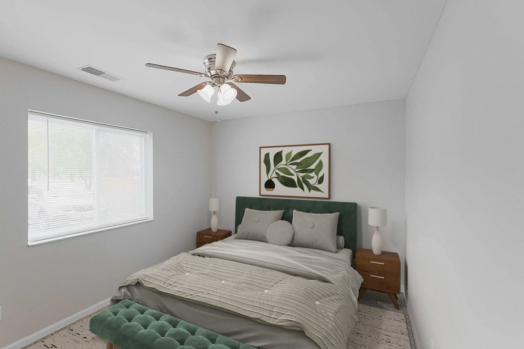 A bedroom with a bed, nightstands, and a ceiling fan.