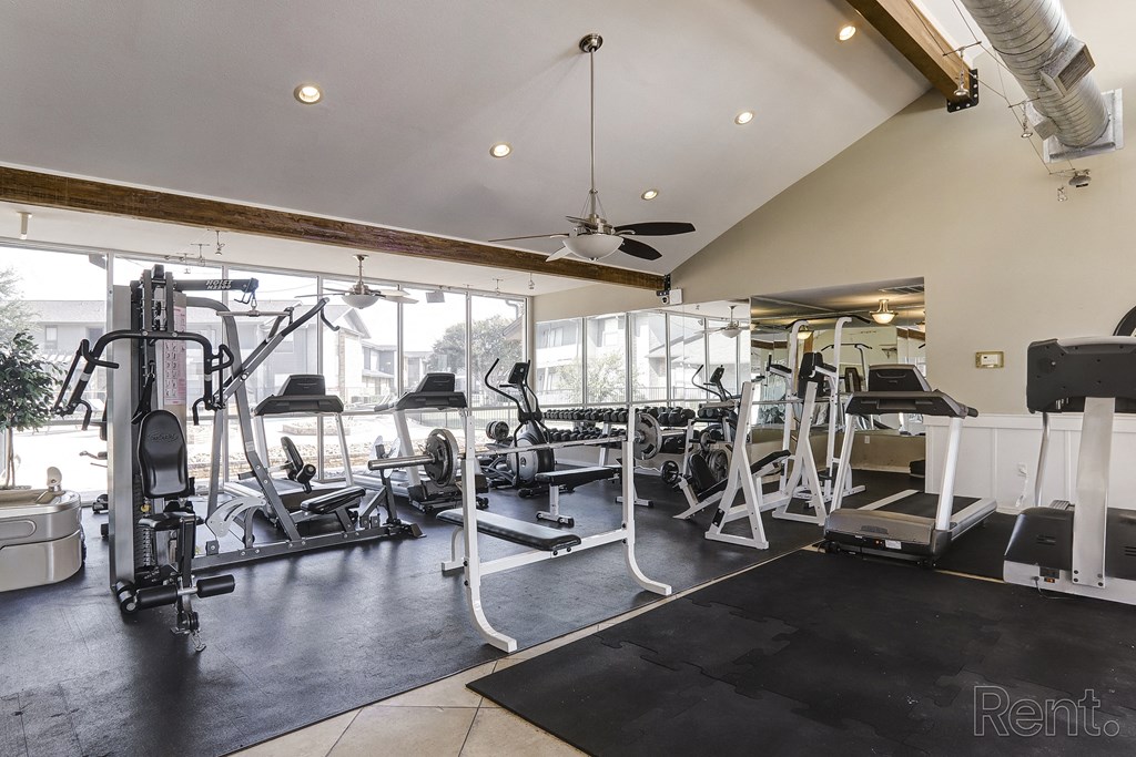 a gym with weights machines and a ceiling fan