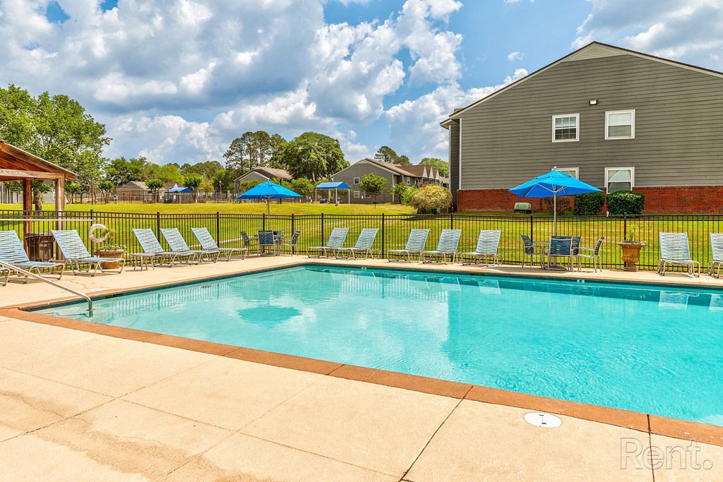 our resort style swimming pool is next to our house with lounge chairs