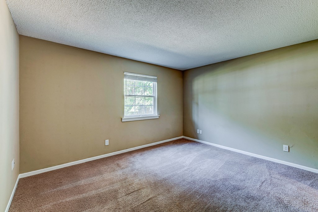 an empty room with carpet and a window
