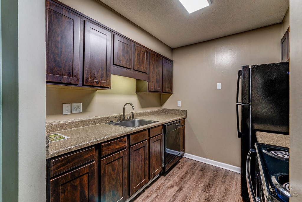 a kitchen with wooden cabinets and a sink and a refrigerator