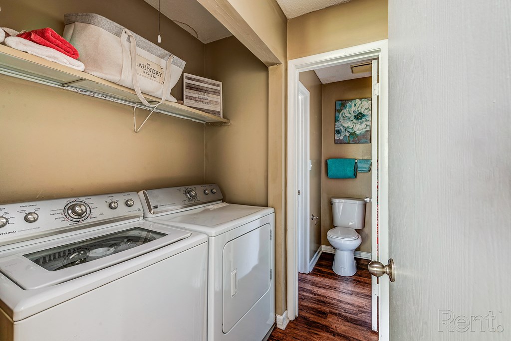 a laundry room with a washer and dryer and a toilet in a bathroom