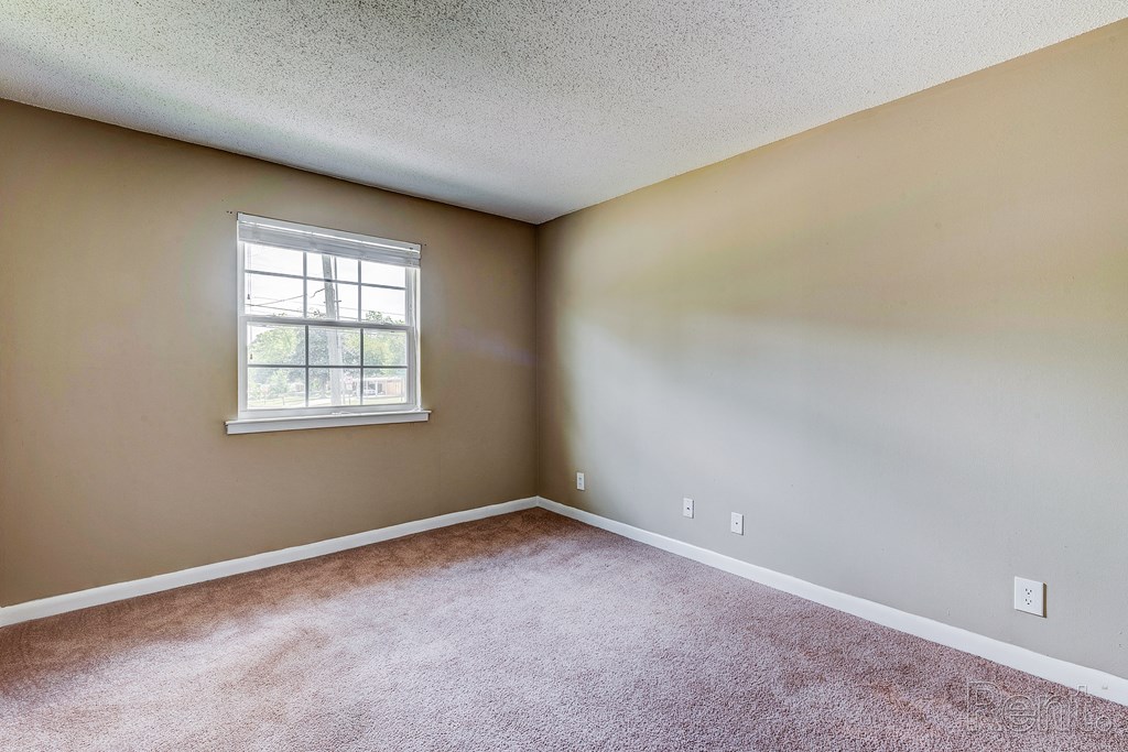 an empty room with carpet and a window