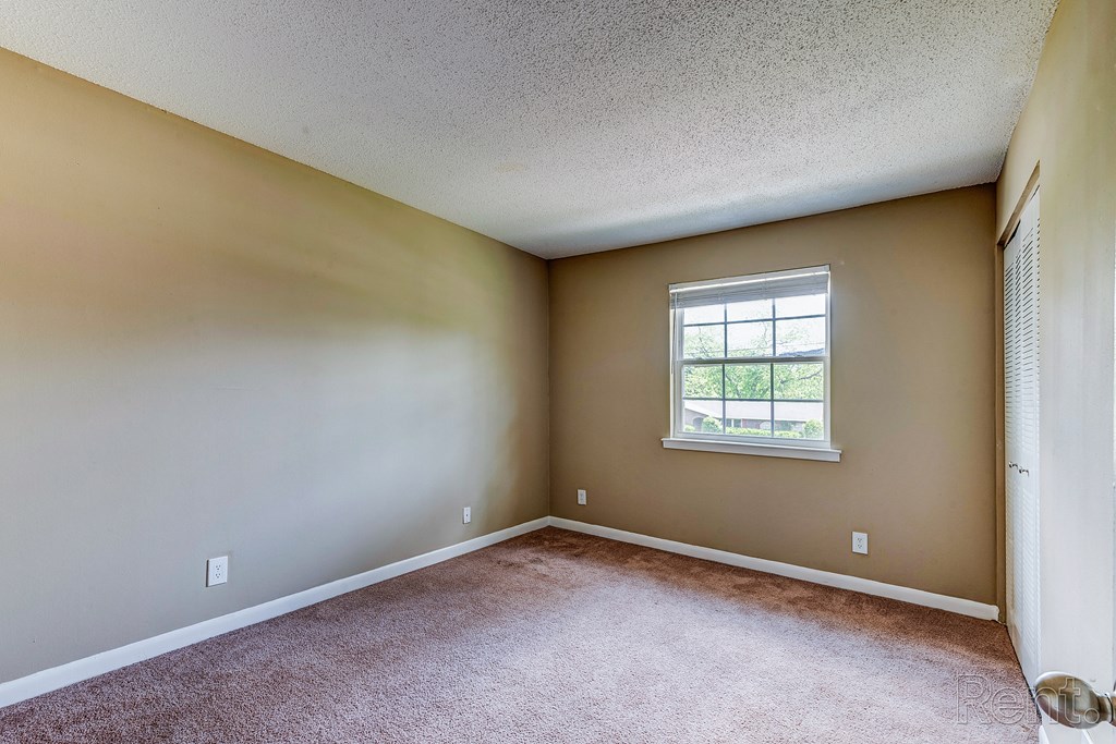 an empty room with carpet and a window