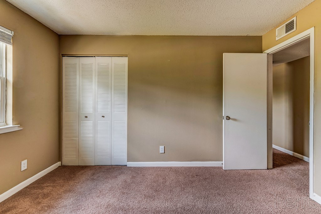 an empty room with a closet and an open door