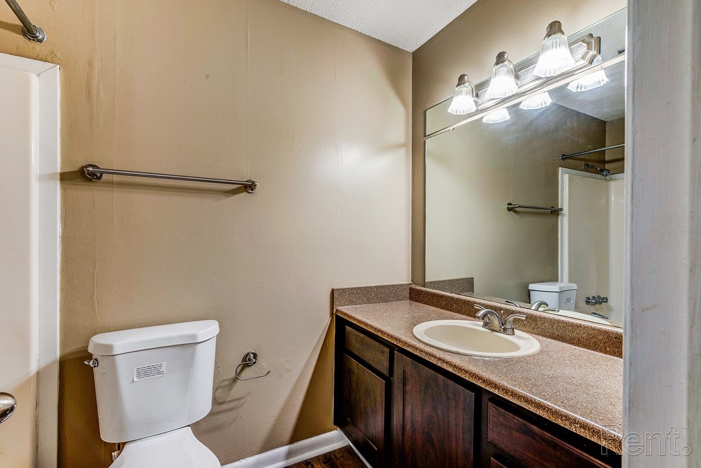 a bathroom with a sink toilet and a mirror