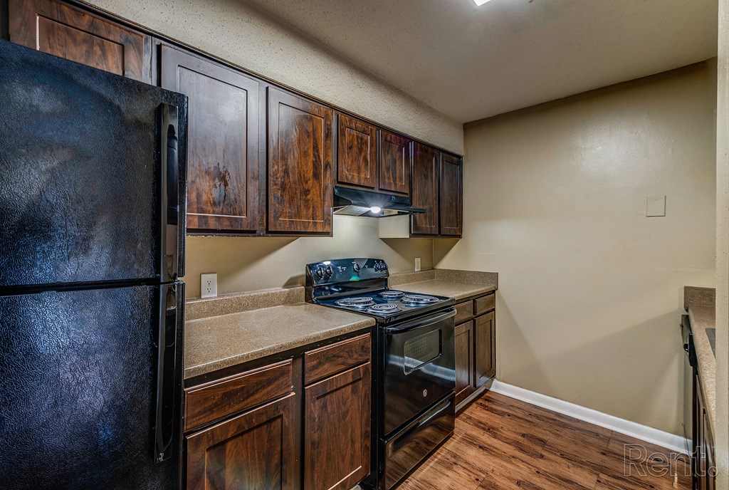 a kitchen with black appliances and wooden cabinets