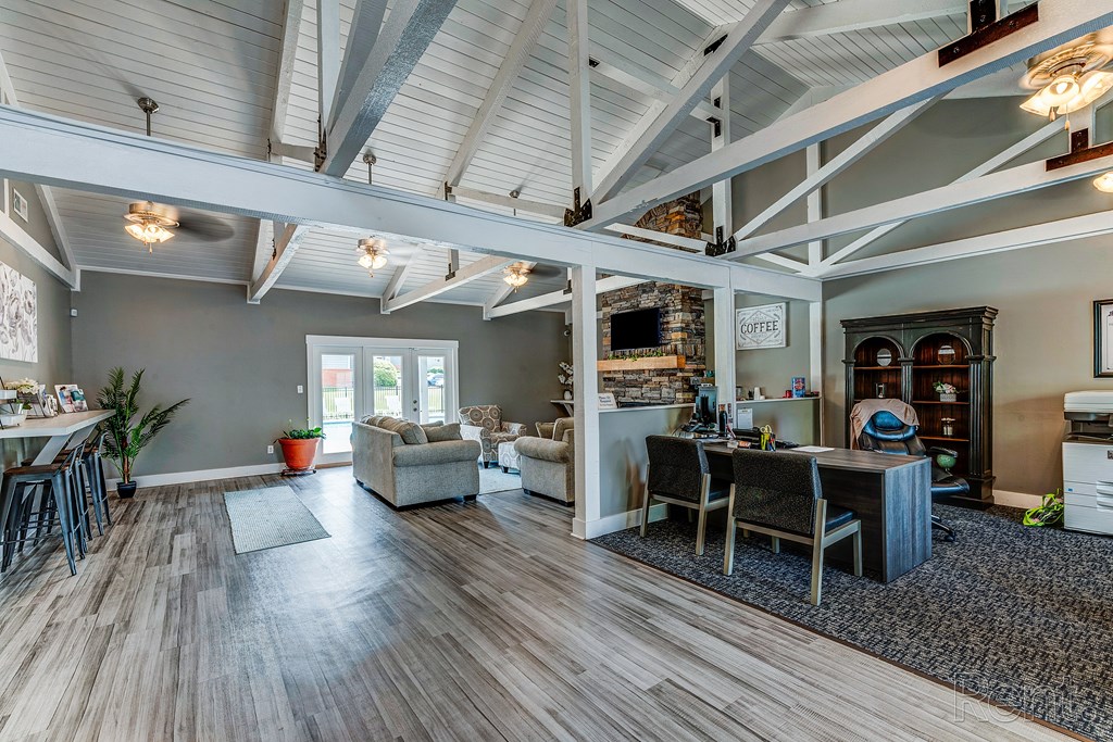 the living room and dining room of a house with wood flooring and exposed ceilings